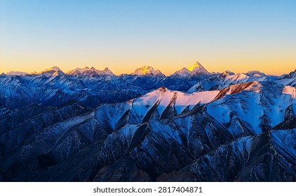Utilizing a unique aerial perspective, this photograph captures the awe-inspiring sunrise deep within the Karakoram Range in Yecheng County, Xinjiang. The frame showcases several legendary 8,000-meter peaks, featuring Mount K2 and Broad Peak. The morning sun bathes the razor-sharp ridges in brilliant golden light, creating a dramatic alpenglow effect. This visual masterwork highlights the supreme majesty of Earth's most extreme high-altitude wilderness and the unmatched depth of drone landscape photography.