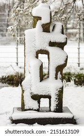 UTRECHT, NETHERLANDS - Apr 02, 2022: Stone Artwork In Public Park In Utrecht Covered In A Thick Layer Of Frost Snow With Greenery Winter Scene In The Background