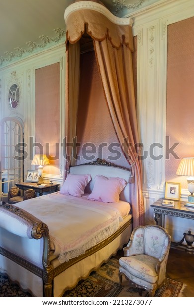 UTRECHT, NETHERLANDS - AUGUST 09, 2022:\
Luxurious large bed ornated with carvings and canopy of embossed\
fringed fabric in Baroness Rothschild chamber in largest castle of\
Netherlands De Haar\
Castle..