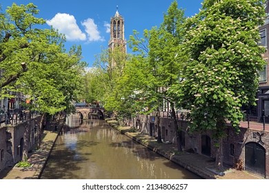 Utrecht, Netherlands. Old canal (Oudegracht) in sunny day, and tower of Utrecht Cathedral in the background.