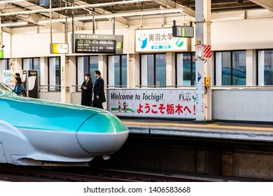 Utsunomiya, Japan - April 5, 2019: Train Station Platform With People Waiting For Shinkansen Bullet Train Arriving At Night Evening With Welcome Sign To Tochigi