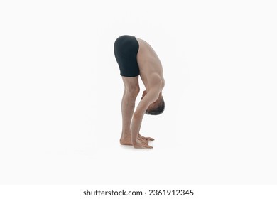 Uttanasana (Standing Forward Bend), Ashtanga yoga. Side view of man wearing sportswear doing Yoga exercise against white background.   - Powered by Shutterstock