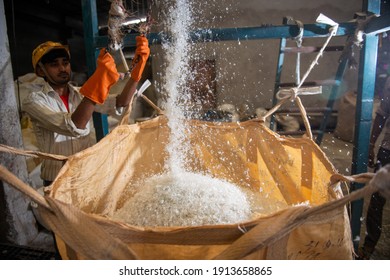Uttar Pradesh, India - 4 February 2021 : crystal clear recycled plastic falling in a sack, they will be used in making of polyester fiber, plastic recycling plant.