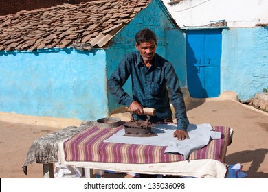 UTTAR PRADESH, INDIA - DEC 20: Asian Man Ironing Clothes Vintage Iron On December 20, 2012 In Orchha, India. 11.2% Uttar Pradesh People Work In The Secondary Sector Of The Economy (manufacturing)