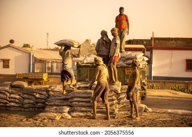 Uttar Pradesh, India- Feb 18 2021: Indian Labour Loading Cement Bag On Tractor Trolley.