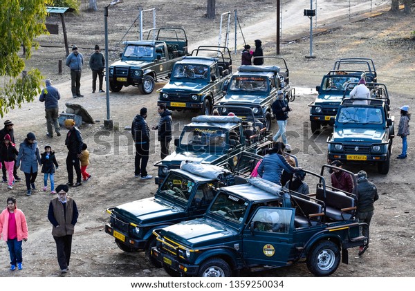 Uttarakhand, India, 2019. Top view of\
group of gypsy cars offroading vehicles with people waiting to\
begin their safari in Jim Corbett National Park tiger\
reserve