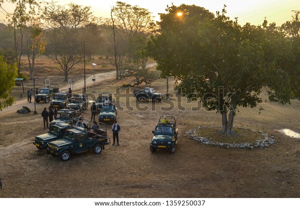 Uttarakhand, India, 2019. Top view of\
a group of gypsy cars offroading vehicles with people waiting to\
begin their safari in Jim Corbett National Park tiger\
reserve