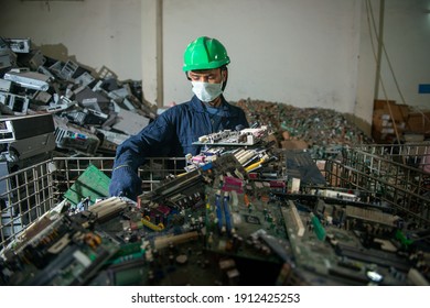 Uttarakhand, India, January 29 2021 : Worker With Discarded Or Obsolete Spare PC Parts And Accessories Such As Mainboards, Colored Cables And Connectors, Electronic Waste Recycling Plant At Haridwar