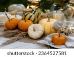 utumn cozy mood table composition for family thanksgiving dinner with wine, pumpkins, candles on wooden tray. Fall mood, warm plaid. Hygge home decor, interior seasonal design