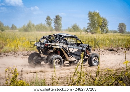 UTV buggy moves on a dusty road. 4x4, extreme, adrenalin.