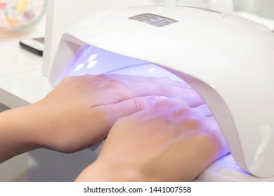 UV Lamp For Drying Varnish For Two Hands. Girl Dries Shellac On Two Hands In A Lamp