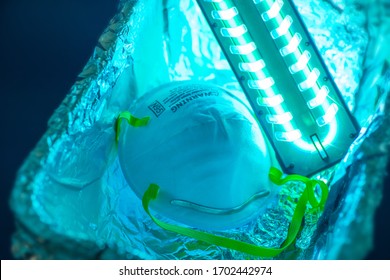 UV light sterilization of face mask to disinfect and reuse. COVID-19 prevention concept.