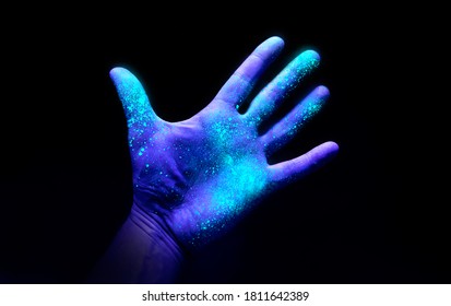 UV Ultraviolet light on a hand illustrating the effect of bacteria and viruses on a surface that has not been washed showing the importance of good hygiene and hand washing.