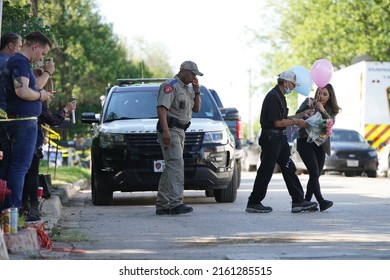 Uvalde, TexasUnited States - May 26, 2022: Community members at the Robb Elementary School memorial pray, visit, and leave tokens of affection at the crosses dedicated to the victims of the shooting