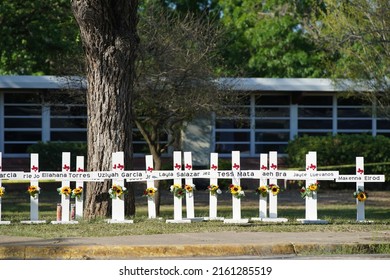 Uvalde, TexasUnited States - May 26, 2022: Community members at the Robb Elementary School memorial pray, visit, and leave tokens of affection at the crosses dedicated to the victims of the shooting