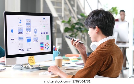 UX designer test phone app development template layout framework wireframe design, User experience concept, Young asian man talking for coding on smartphone for application test at office - Shutterstock ID 1789864781