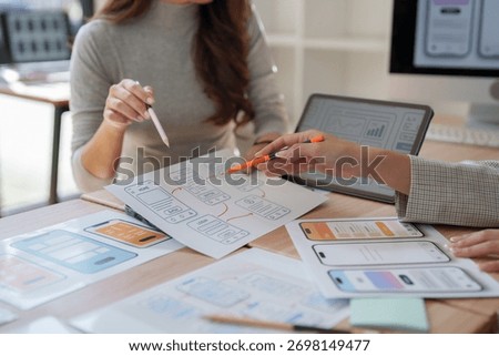 Ux designers discussing and developing mobile app prototypes and user interface wireframes, working on creative workflow at office