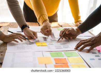 UX developer and ui designer brainstorming about mobile app interface wireframe design with customer breif and color code at office.