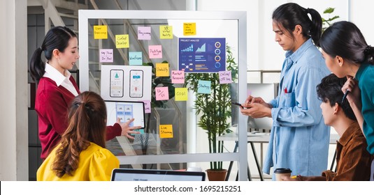 Ux Developer And Ui Designer Presenting  And Testing Mobile App Interface Design On Whiteboard In Meeting At Modern Office.Creative Digital Development Mobile App Agency