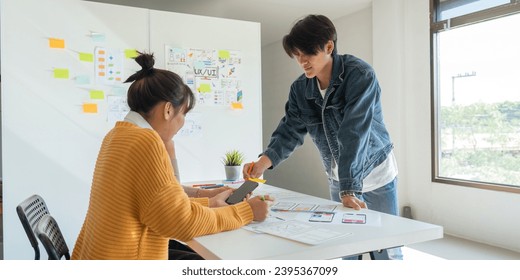 Ux developer and ui designer use augmented reality brainstorming about mobile app interface wireframe design on desk at modern office. creative digital development agency - Shutterstock ID 2395367099