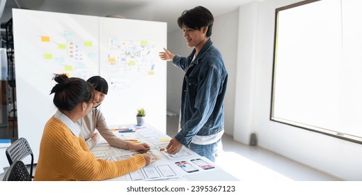 Ux developer and ui designer use augmented reality brainstorming about mobile app interface wireframe design on desk at modern office. creative digital development agency - Shutterstock ID 2395367123