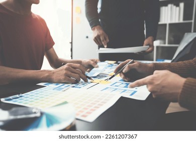 ux developers, UI designers Asian group data researchers brainstorm on tabletop mobile app interface wireframe design client summary color codes modern office Creative Digital Development Agency. - Shutterstock ID 2261207367
