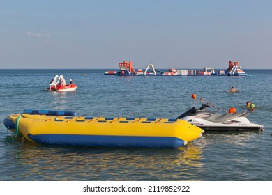 Uyutnoye village, Saksky district, Evpatoria, Crimea, Russia - July 18, 2021: An inflatable banana and a jet ski are waiting for passengers on a water attraction near the Surer Aqua beach