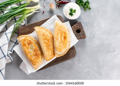 Uzbek eastern Tatar cuisine, cheburek with meat and greens on a wooden board. Cheburek - fried pie with meat and onions. Traditional dish of Turkish and mongolian. Top view. Copy space. - Shutterstock ID 1964160058