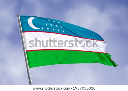 Uzbekistan flag isolated on sky background. close up waving flag of Uzbekistan. flag symbols of Uzbekistan.