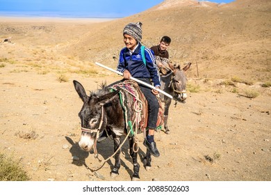 Uzbekistan, In The Naratau Mountains Children Coming Back From School Riding On A Donkey. 7th Of October 2021