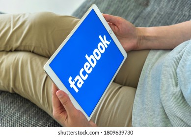 Uzhgorod, Ukraine - September 6, 2020: Woman Hands Using IPad With Facebook Homepage On Screen. Facebook The Biggest Social Network Website.