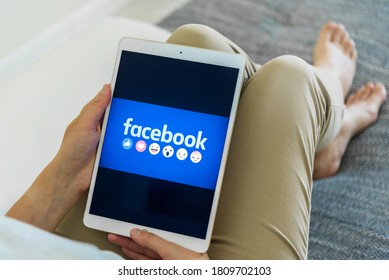 Uzhgorod, Ukraine - September 6, 2020: Woman Hands Using IPad With Facebook Homepage On Screen. Facebook The Biggest Social Network Website.