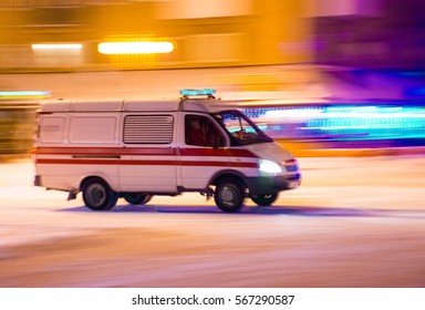 UZHGOROD,UKRAINE - JANUARY 12, 2017: Ambulance In Motion Driving Down The Road At Night In Uzhgorod, Ukraine. Winter Time.  Intentional Motion Blur