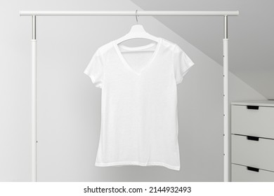 V Neck T-shirt Hanging On Clothing Rack. White Color. Template, Mock Up