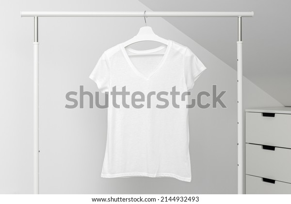 V neck t-shirt hanging on Clothing rack. White color.\
Template, mock up