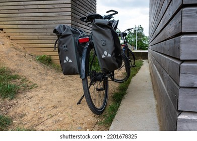 Vaalbeek, Flemish Brabant Regio, Belgium - 08 21 2022 - Trekking Bike With Luggage Standing Against A Wooden Wall