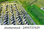 Vacant land near large RV park campsite with long row of recreational vehicles, trailers boats and tall palm trees in South Padre Island, aerial view basecamp with full power hookup, Texas. USA