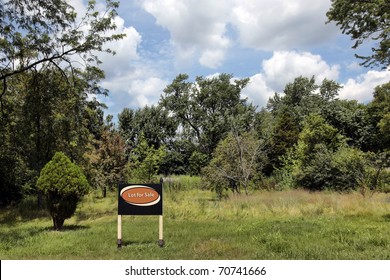 Vacant land in suburbs with "Lot for Sale" sign