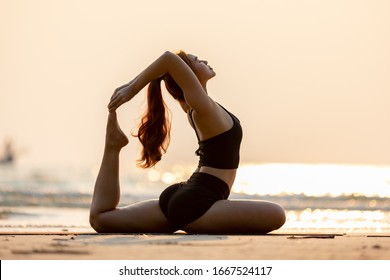 Vacation of Attractive Asian woman relaxing in yoga king pigeon pose on the sand and beach with sunset beautiful sea in Tropical island,Feeling comfortable and relax in holiday,Yoga Vacations Concept - Powered by Shutterstock