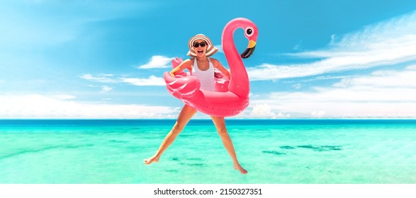Vacation beach woman jumping of joy with pink flamingo pool float for summer holidays on ocean banner background. Fun travel excited girl for luxury Caribbean holiday panoramic. - Shutterstock ID 2150327351