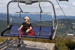 Vacation In Carpathian Mountains. Woman On The Lift In The Mountains In Summer. Ukrainian Ski Lift Transportation.
