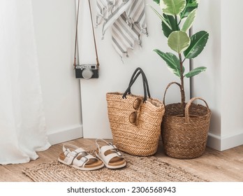 Vacation concept. Straw bag, comfortable sandals, beach towel, camera in a cozy bright room   - Powered by Shutterstock