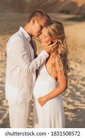Vacation couple in white clothes walking on the beach together in love. Happy young people, pregnancy woman, motherhood. Summer romance.