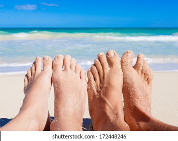 Vacation Holiday. Close Up Of Young Couple Feet Relaxing On Beach.