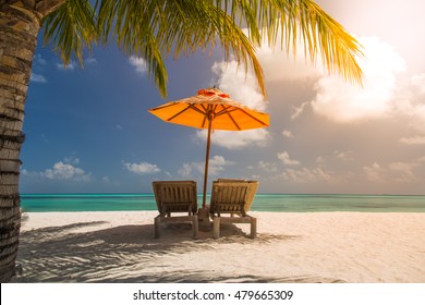 Vacation holidays background wallpaper - two beach lounge chairs under tent on beach in Maldives.