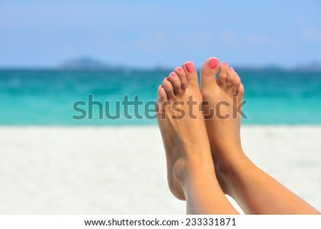 Vacation holidays. Woman feet closeup of girl relaxing on beach on sunbed enjoying sun on sunny summer day.