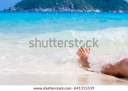 Vacation holidays. Woman feet closeup of girl relaxing on beach on sunbed enjoying sun on sunny summer day.