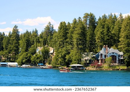 Vacation Homes with private docks on an alpine lake surrounded by pine trees taken at the resort mountain town of Lake Arrowhead, CA in the San Bernardino Mountains