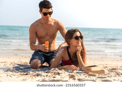 Vacation love young happy smile couple in honeymoon travel holiday trip standing on sand at blue sky sea beach applying suncream with sun drawn on tropical beach.Summer travel - Powered by Shutterstock