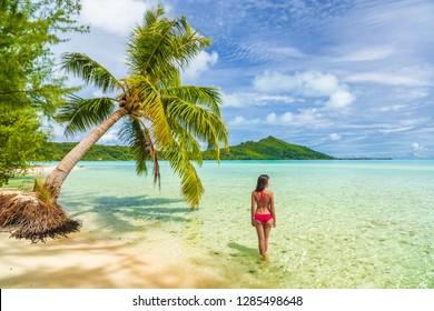 Vacation Luxury Travel woman walking on Tahiti paradise motu beach Bora Bora on holidays on Bora Bora with. Happy girl Bikini in Tahiti, French Polynesia.